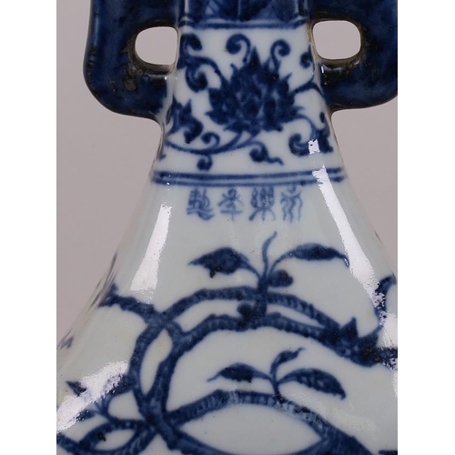 23 - A Chinese blue and white porcelain two handled vase with flowering tree decoration, four character m... 