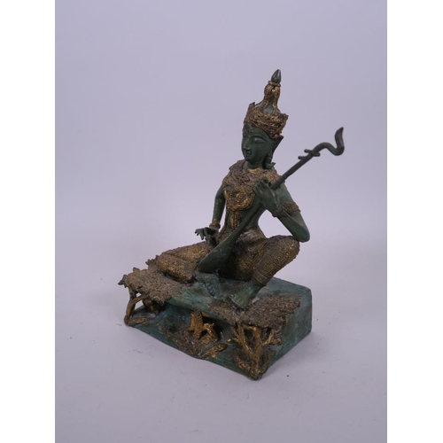 37 - A Thai bronze figure of a musician in traditional garb with green and gilt patina, 8