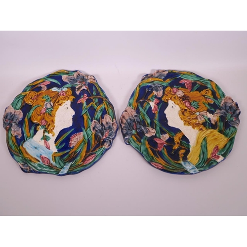 67 - A pair of Majolica wall plaques in the Art Nouveau style decorated with flower girls, 12