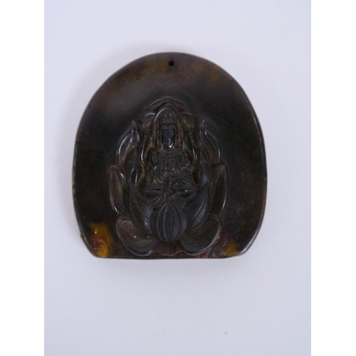 71 - A Chinese carved horn and composition pendant with Quan Yin decoration, 2½