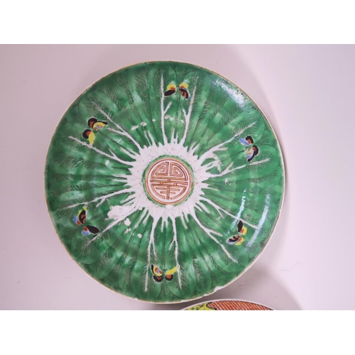 72 - A Chinese porcelain plate decorated with butterflies on a green ground and central medallion, 9½