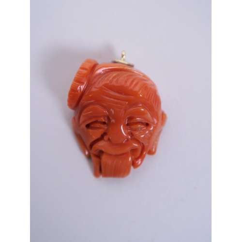 80 - A Chinese carved coral pendant in the form of a sage's head, 1