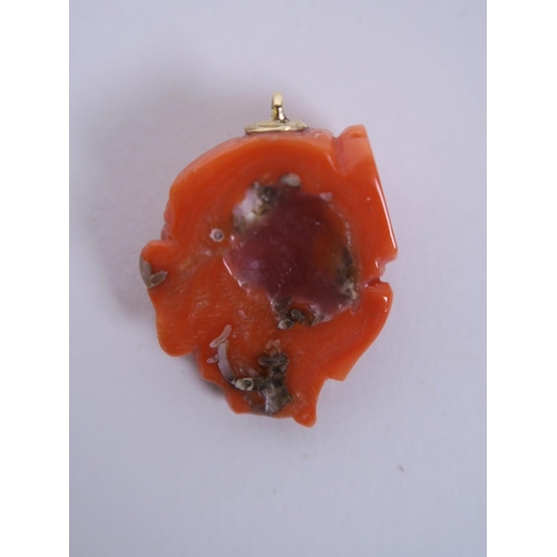 80 - A Chinese carved coral pendant in the form of a sage's head, 1