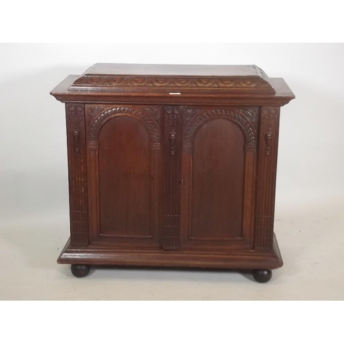 863 - A C19th French oak two door cabinet with carved and fluted decoration, raised on bun feet, 33