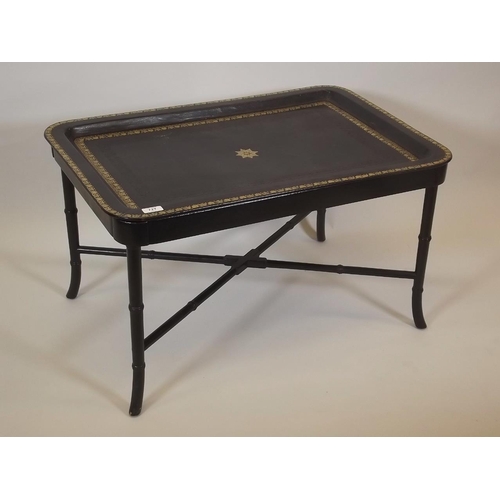 867 - A gilt tooled leather topped tray by Maitland Smith on an ebonised stand with ring turned supports, ... 