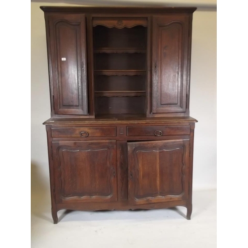 884 - A C19th French oak buffet a deux corps, the base section with two drawers over two cupboards, the up... 