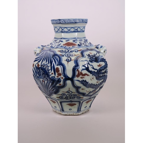 93 - A Chinese octagonal blue and white pottery jar with mask handles and decorative panels with red high... 