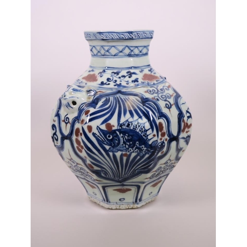 93 - A Chinese octagonal blue and white pottery jar with mask handles and decorative panels with red high... 