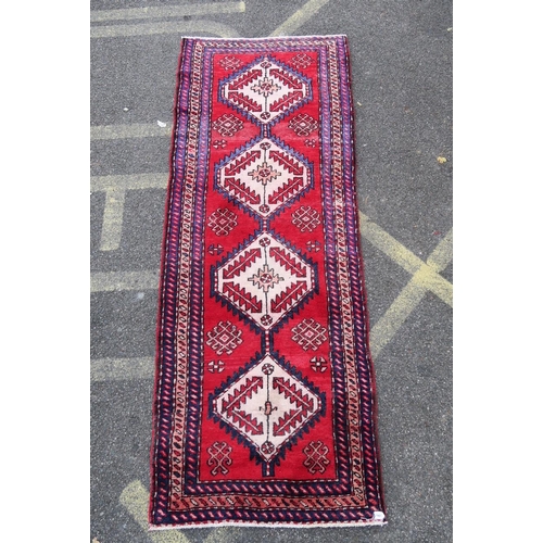 1165 - A Persian red and blue ground wool runner, with medallion design decoration, 39