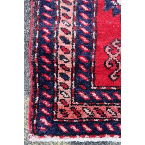 1165 - A Persian red and blue ground wool runner, with medallion design decoration, 39