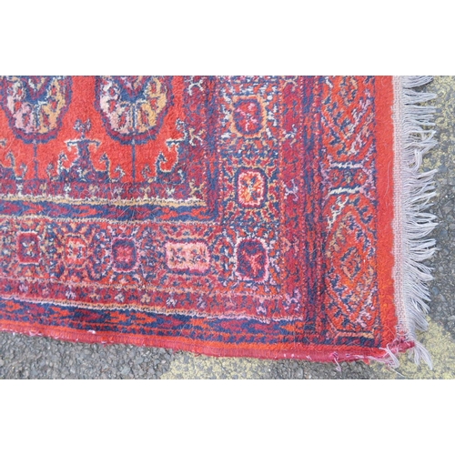 1171 - A pair of rust ground wool rugs with a Bokhara design, 52