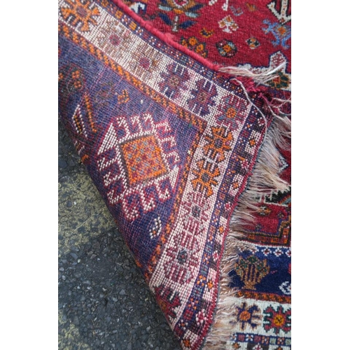 1172 - A Persian red and blue ground rug with bird and central medallion decoration, 42