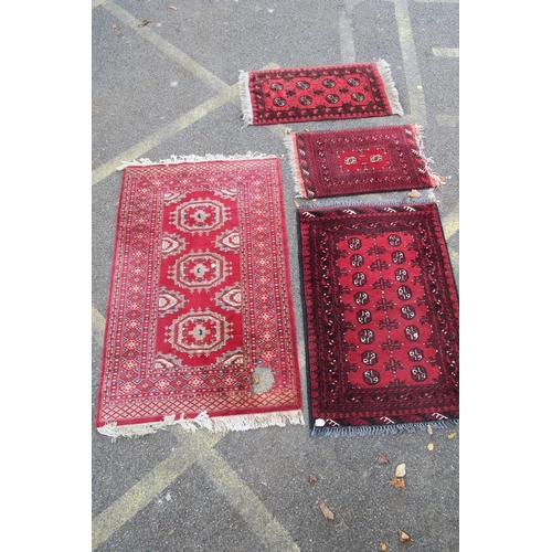 1173 - A Persian red ground Bokhara rug, together with two small and another red ground Persian rug, A/F ho... 