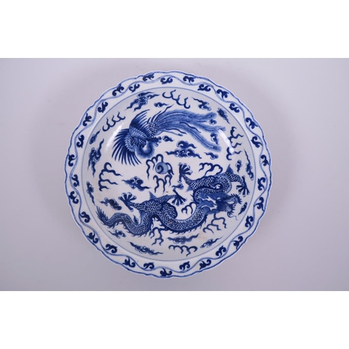 10 - A Chinese blue and white porcelain dish with lobed rim, decorated with a dragon and phoenix chasing ... 