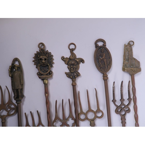 21 - A collection of ten brass toasting forks, the handles cast with various town and country characters ... 