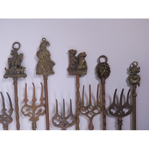 21 - A collection of ten brass toasting forks, the handles cast with various town and country characters ... 