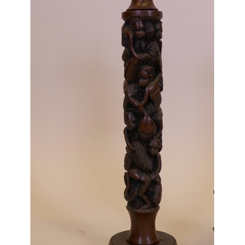 54 - An Eastern hardwood table lamp carved with monkey decoration, and a Balinese carving of a dancer, 18... 