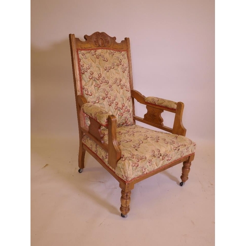 1209 - A Victorian satin walnut open armchair, with carved crest, raised on turned supports