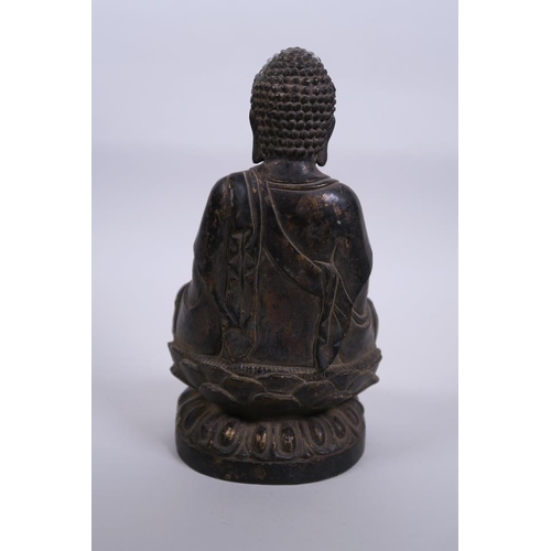 11 - A Chinese bronze figure of Buddha seated on a lotus throne with a gilt patina, 8