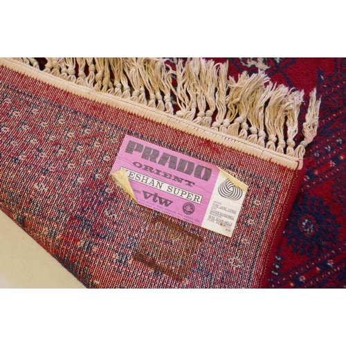 1205 - A Persian style red ground carpet with Bokhara decoration, 55