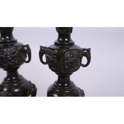 40 - A pair of C19th Japanese  bronze candlesticks with two elephant mask handles and raised decoration o... 