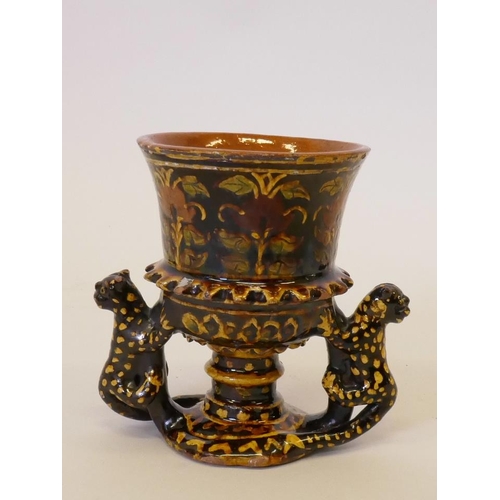 57 - A slipware pottery goblet with polychrome floral decoration and leopard handles, 5