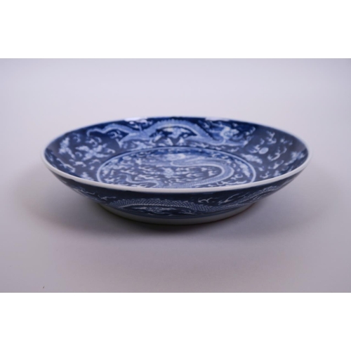 58 - A Chinese blue and white porcelain charger decorated with a dragon chasing the flaming pearl, 6 char... 