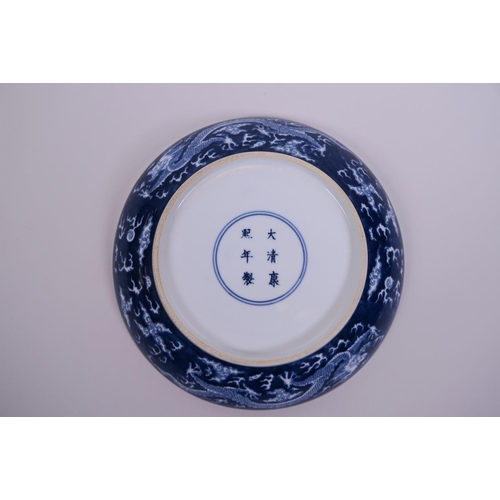 58 - A Chinese blue and white porcelain charger decorated with a dragon chasing the flaming pearl, 6 char... 