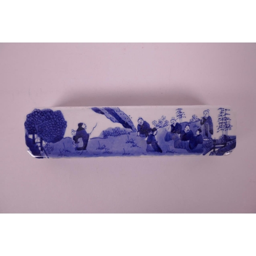 19 - A Chinese blue and white porcelain scroll weight decorated with recumbent figures in a garden, 7½