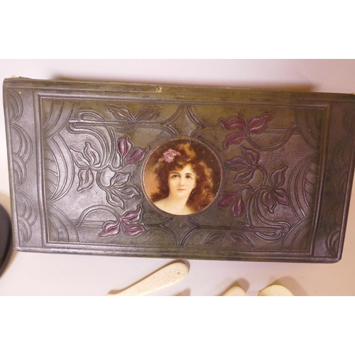 32 - An Art Nouveau leather trinket box containing a collection of bone and ivory paper knives, glove str... 