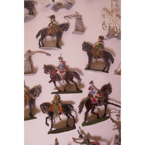 46 - A collection of over seventy early flat back toy soldiers including infantrymen, cavalry, cannon etc... 