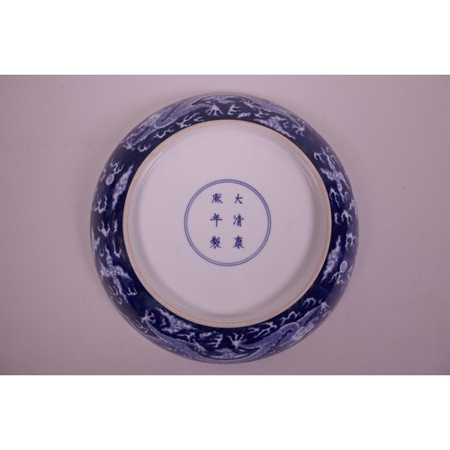 55 - A Chinese blue and white porcelain charger decorated with dragons chasing the flaming pearl, 6 chara... 