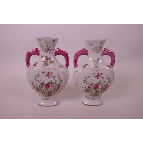 20 - A pair of Chinese polychrome porcelain vases with two handles and heart shaped decorative panels dep... 