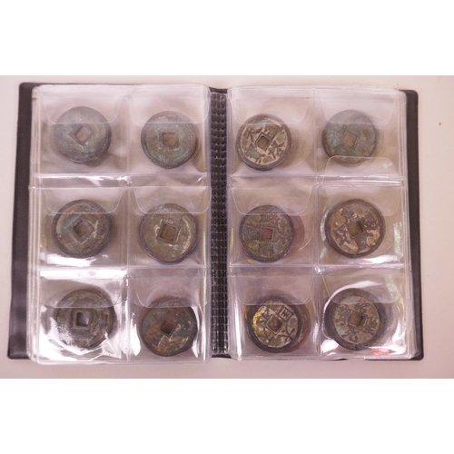 22 - A small wallet of facsimile (replica) Chinese bronze and white metal coinage, largest 1½