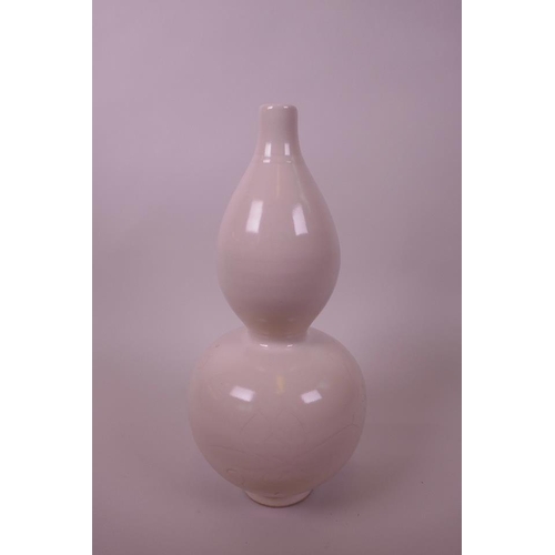 40 - A Chinese cream glazed double gourd vase with incised foliate decoration, 11