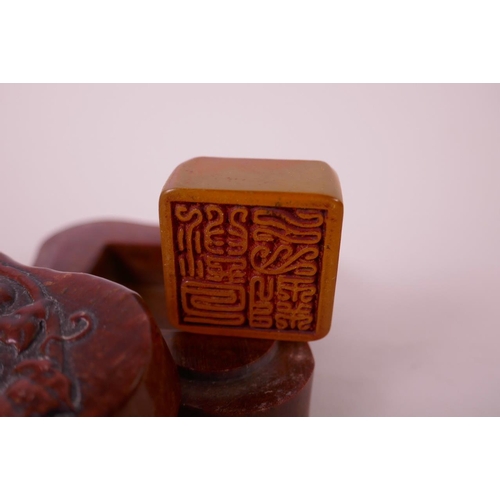 49 - A Chinese soapstone box and cover with carved vine decoration to lid, opening to reveal an amber soa... 