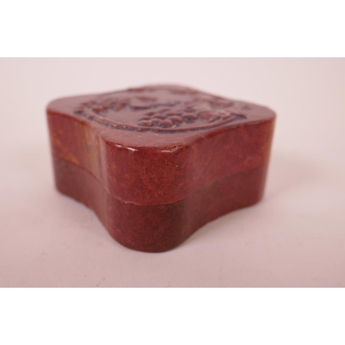 49 - A Chinese soapstone box and cover with carved vine decoration to lid, opening to reveal an amber soa... 