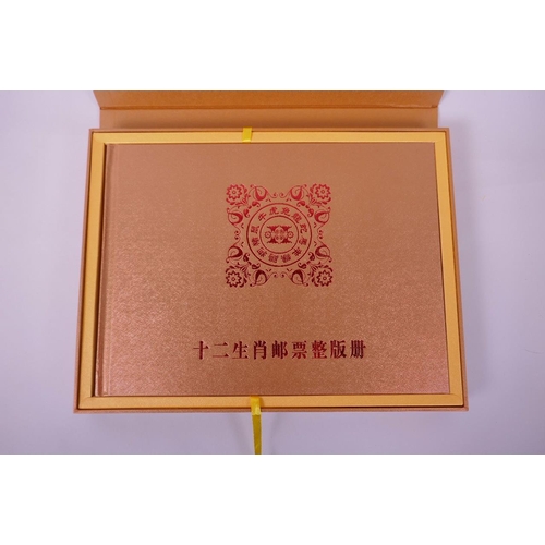 51 - A cased collector's book of facsimile (replica) Chinese stamps commemorating the twelve years from 1... 