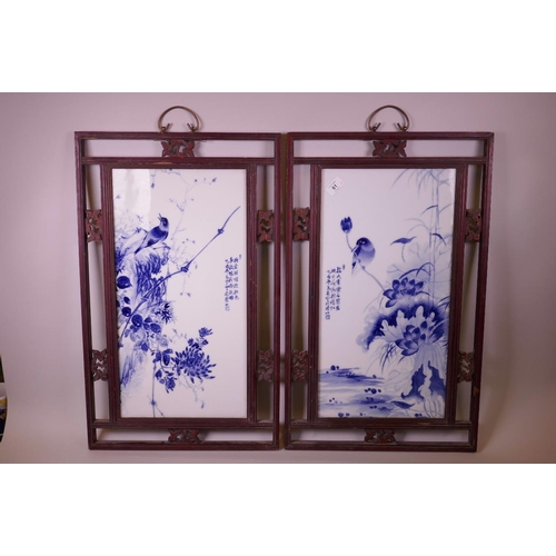 61 - A pair of Chinese blue and white porcelain panels depicting birds amongst flowers, mounted in carved... 