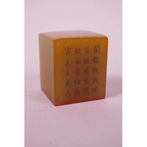 11 - A Chinese amber soapstone seal, decorated with character inscriptions to side, 1½