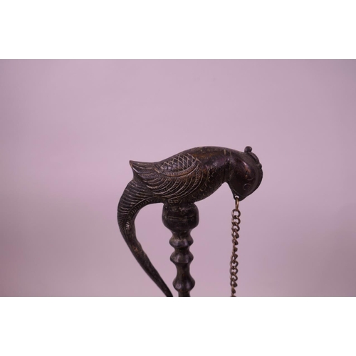 42 - An Indian patinated bronze hanging oil lamp, in the form of a parrot on its perch, 10½