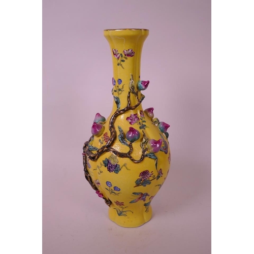 43 - A Chinese yellow ground porcelain vase with a lobed body, decorated with an applied polychrome peach... 