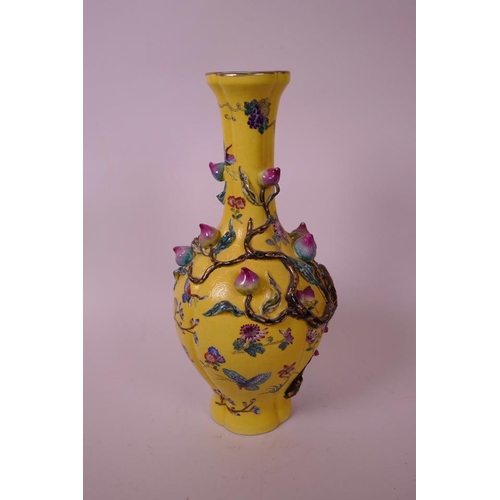 43 - A Chinese yellow ground porcelain vase with a lobed body, decorated with an applied polychrome peach... 