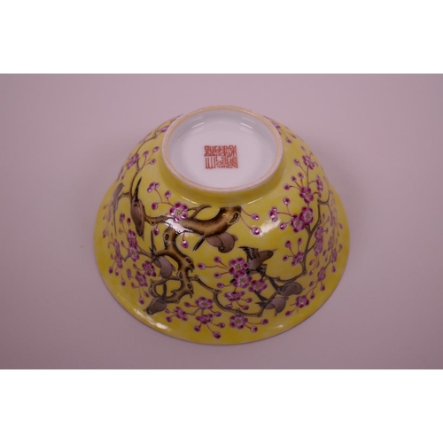 25 - A Chinese yellow ground porcelain rice bowl with polychrome enamelled decoration of birds in a prunu... 