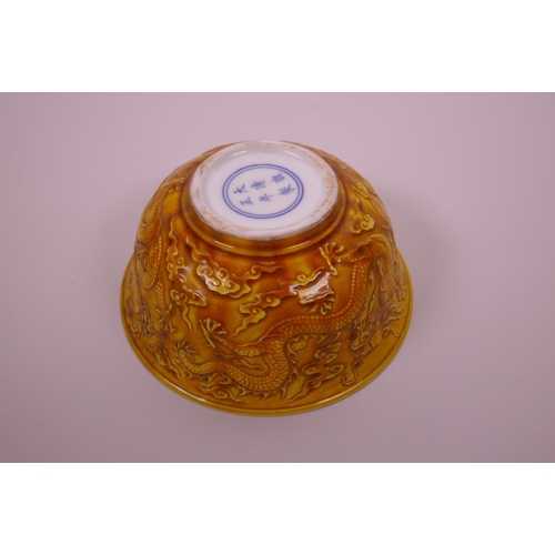 3 - A Chinese yellow ground porcelain rice bowl with raised dragon decoration, 6 character mark to base,... 