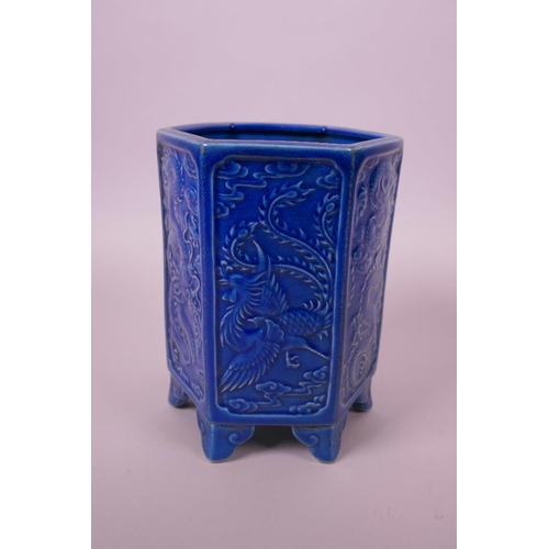 33 - A Chinese blue ground hexagonal brush pot with raised decorative panels depicting dragons and phoeni... 