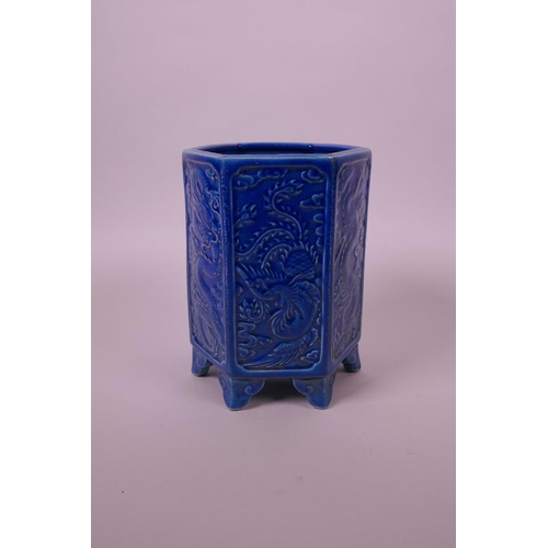 33 - A Chinese blue ground hexagonal brush pot with raised decorative panels depicting dragons and phoeni... 