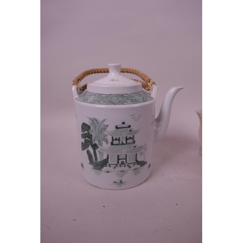 34 - A vintage 'OverJoy' porcelain teapot with wicker handles decorated with a pagoda on a lake shore mar... 