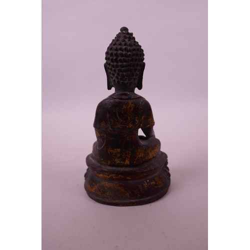 37 - A Chinese bronze of Buddha with a copper and gilt patina, 7