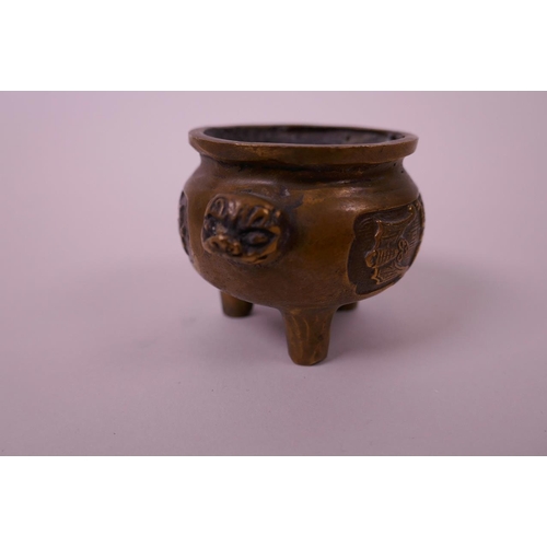 5 - A Chinese bronze censer raised on tripod feet with two kylin mask handles, decorated with stylised b... 